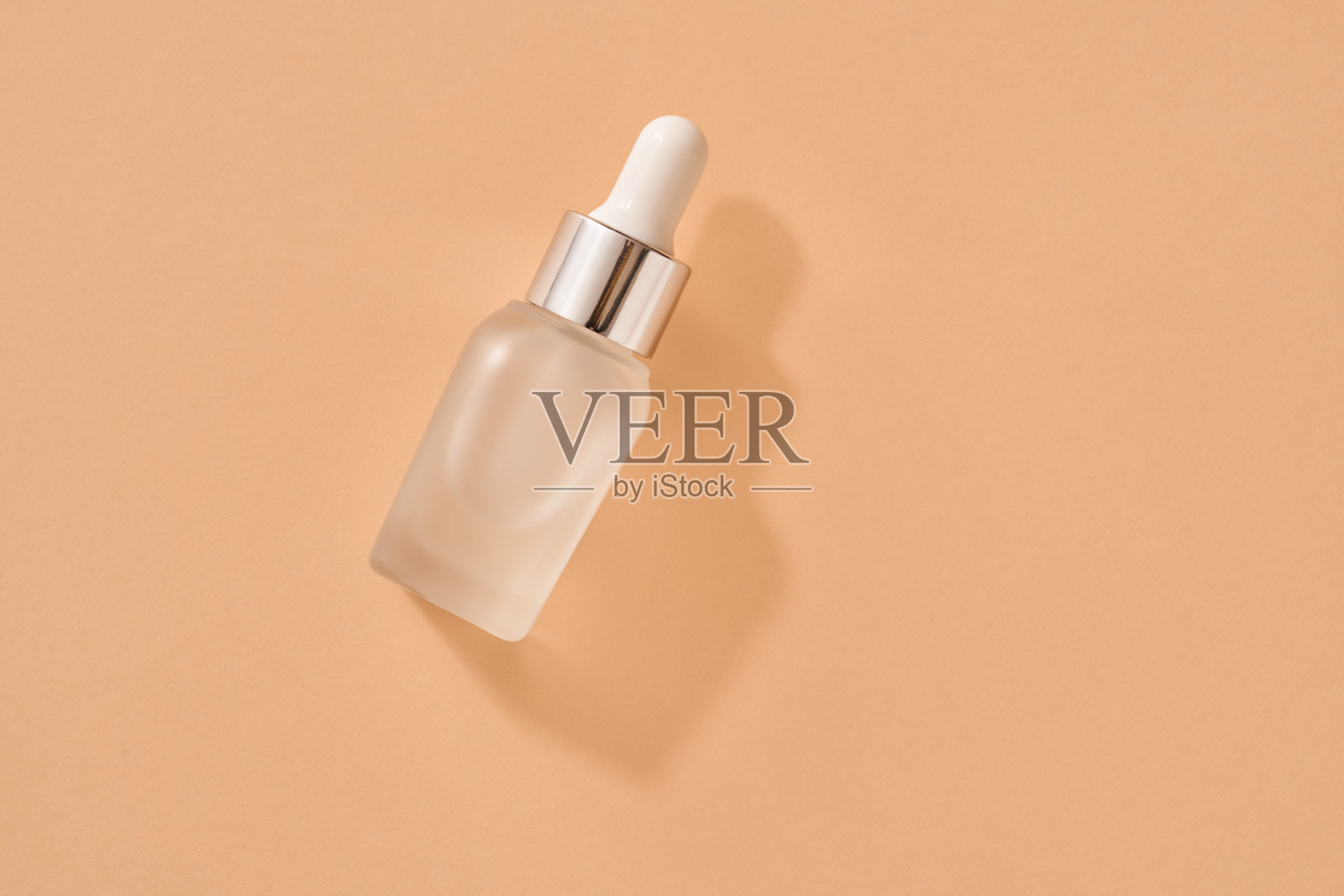 一瓶香薰精油在柔和的橙色背景上照片摄影图片