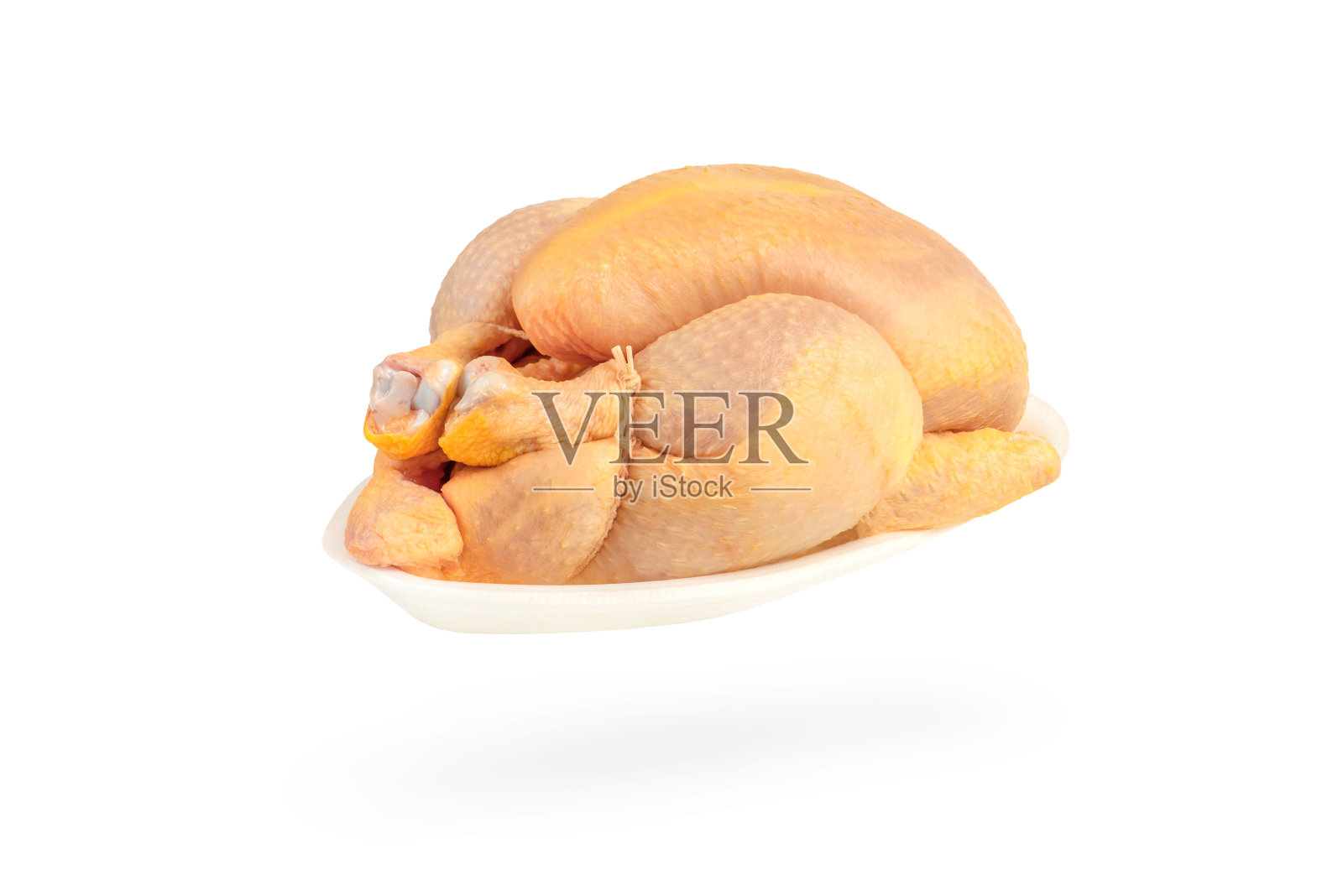 生玉米鸡孤立在白色背景。鸡的尸体装在一个白色的塑料托盘里。黄肉鸡饲料玉米照片摄影图片