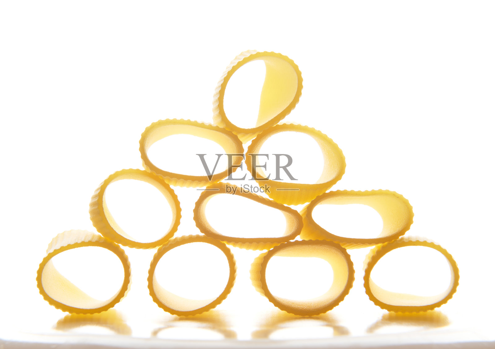 近距离，工作室用柔和的阴影拍摄了一个全麦意大利面食- tortiglioni-整齐地排列成金字塔的形状。食品的背景照片摄影图片