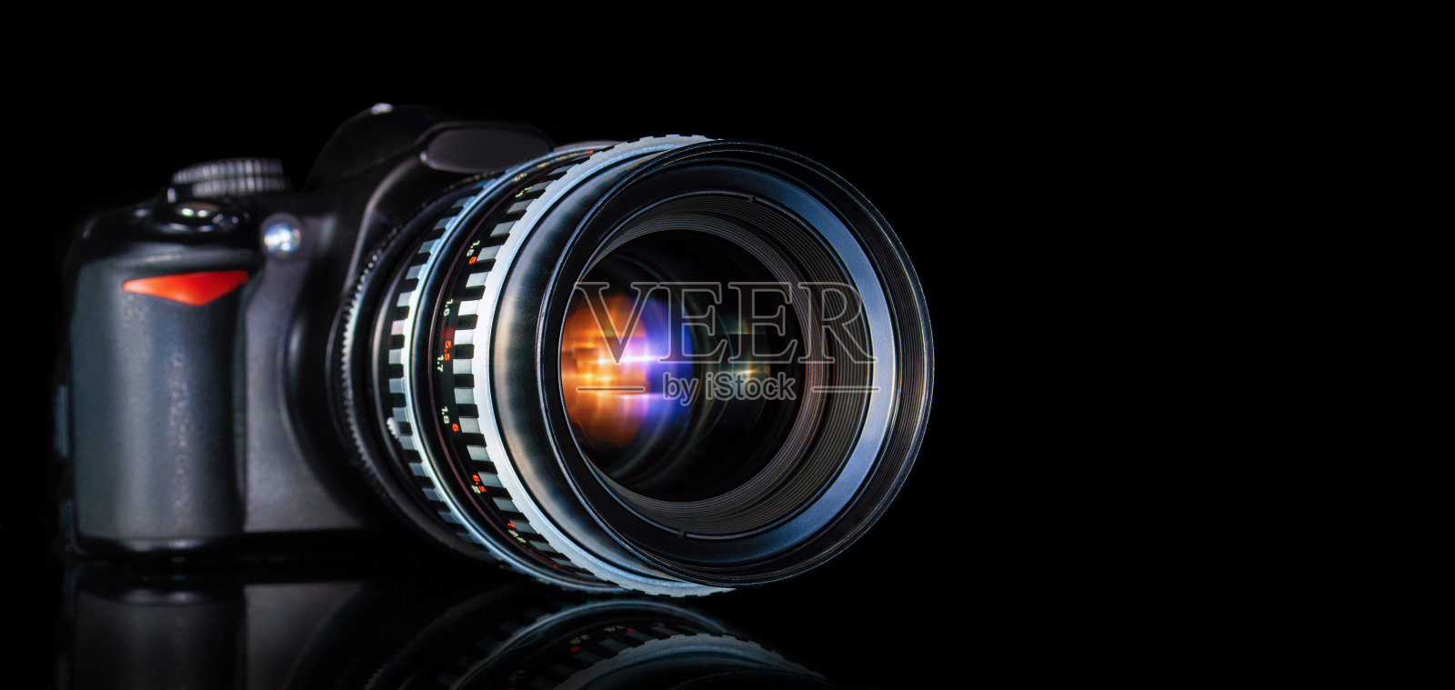 现代单反相机和复古远摄镜头接近黑色背景反射照片摄影图片
