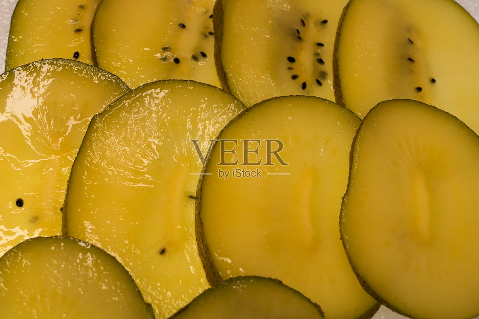 黄色猕猴桃切片特写。照片摄影图片