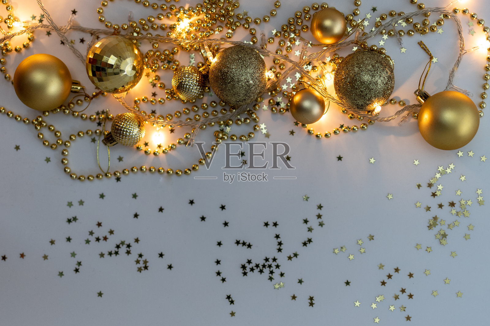 圣诞假期的构图，顶部的金色圣诞装饰和花环与灯在黄色的背景与文本的复制空间。模糊。平的。冬天,明信片模板照片摄影图片