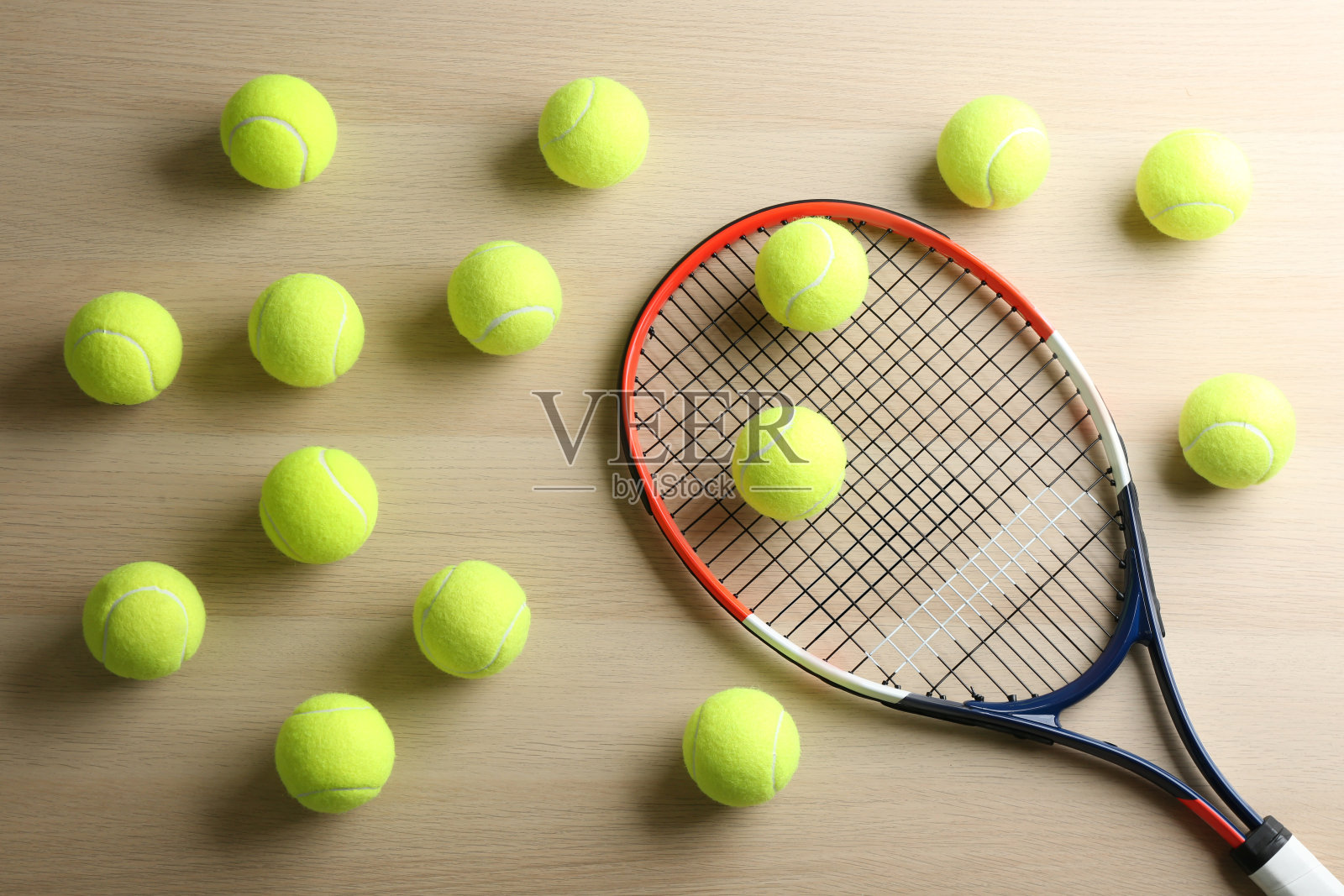 网球拍和球放在木桌上，平放。运动器材照片摄影图片