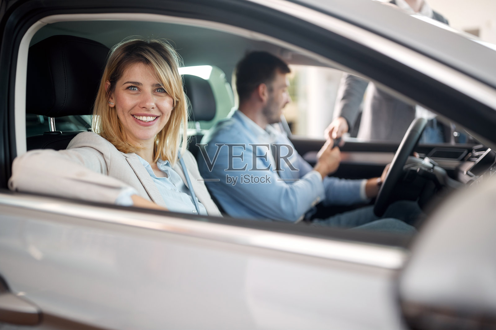 幸福的一家人坐在他们在汽车店买的新车里。汽车,商店,购买照片摄影图片