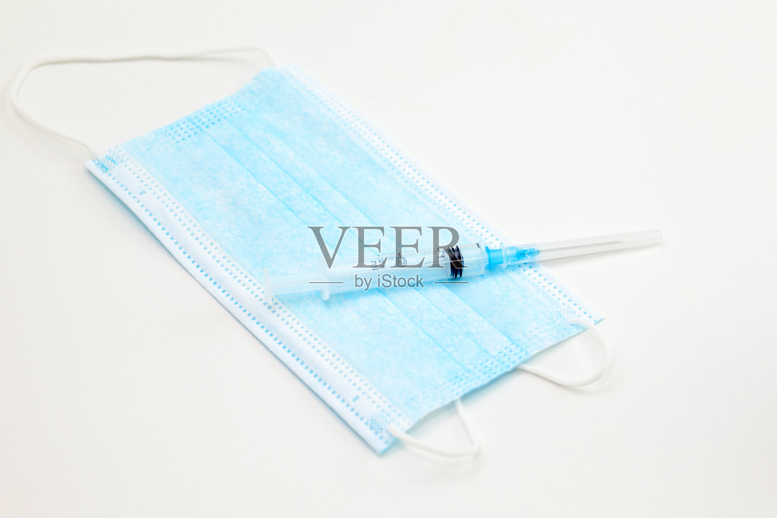 医用口罩和注射器，白色背景照片摄影图片