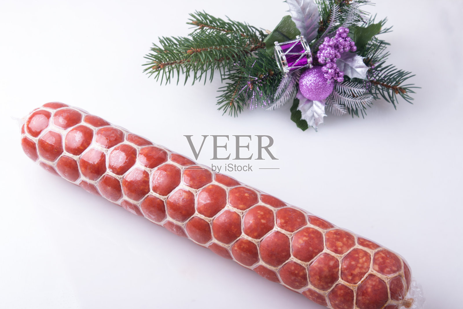 节日香肠。绿色的云杉枝上白色的背景新年照片摄影图片