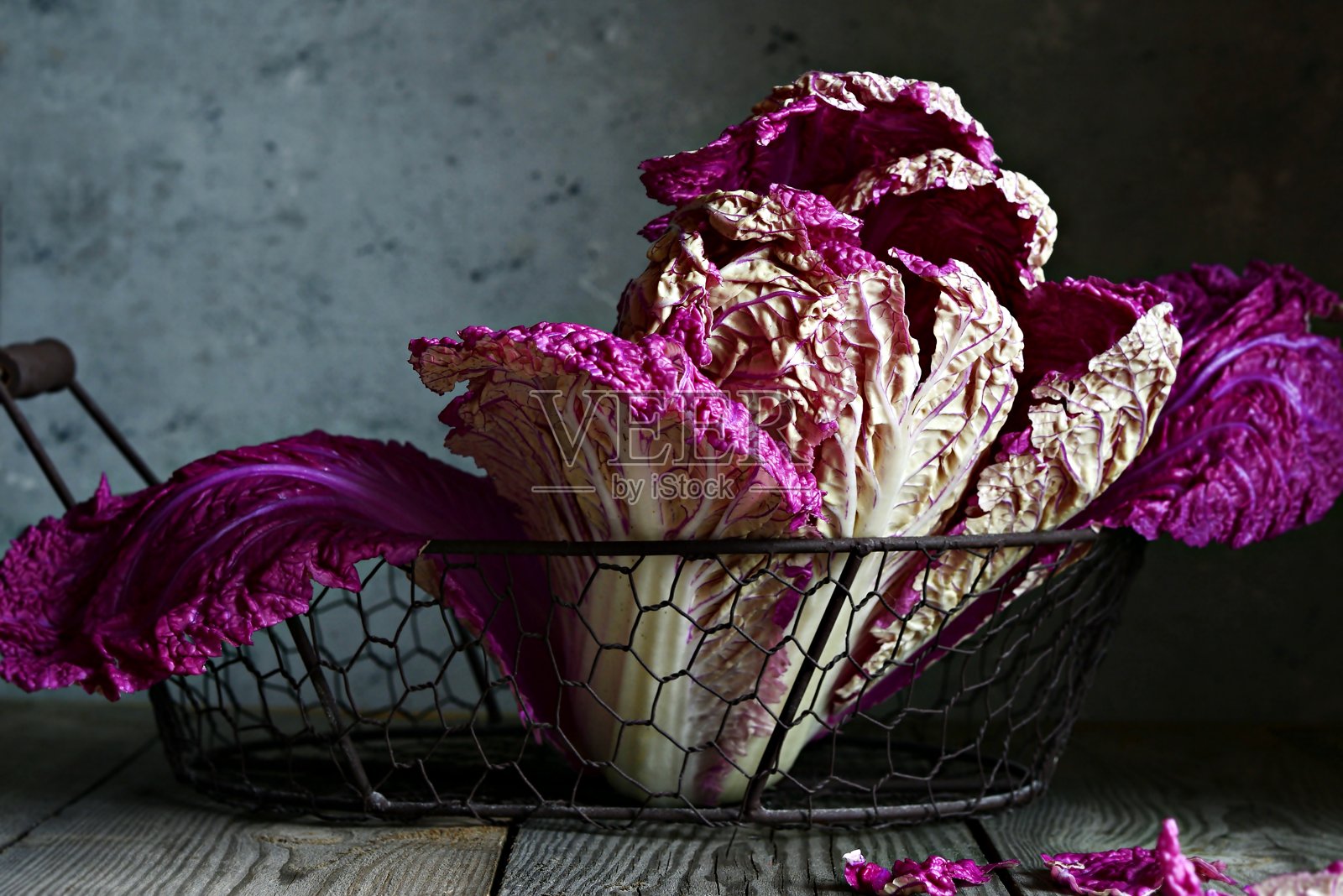 在深色的木质背景下，篮子里摆着一棵新鲜的紫色中国(北京)白菜。照片摄影图片