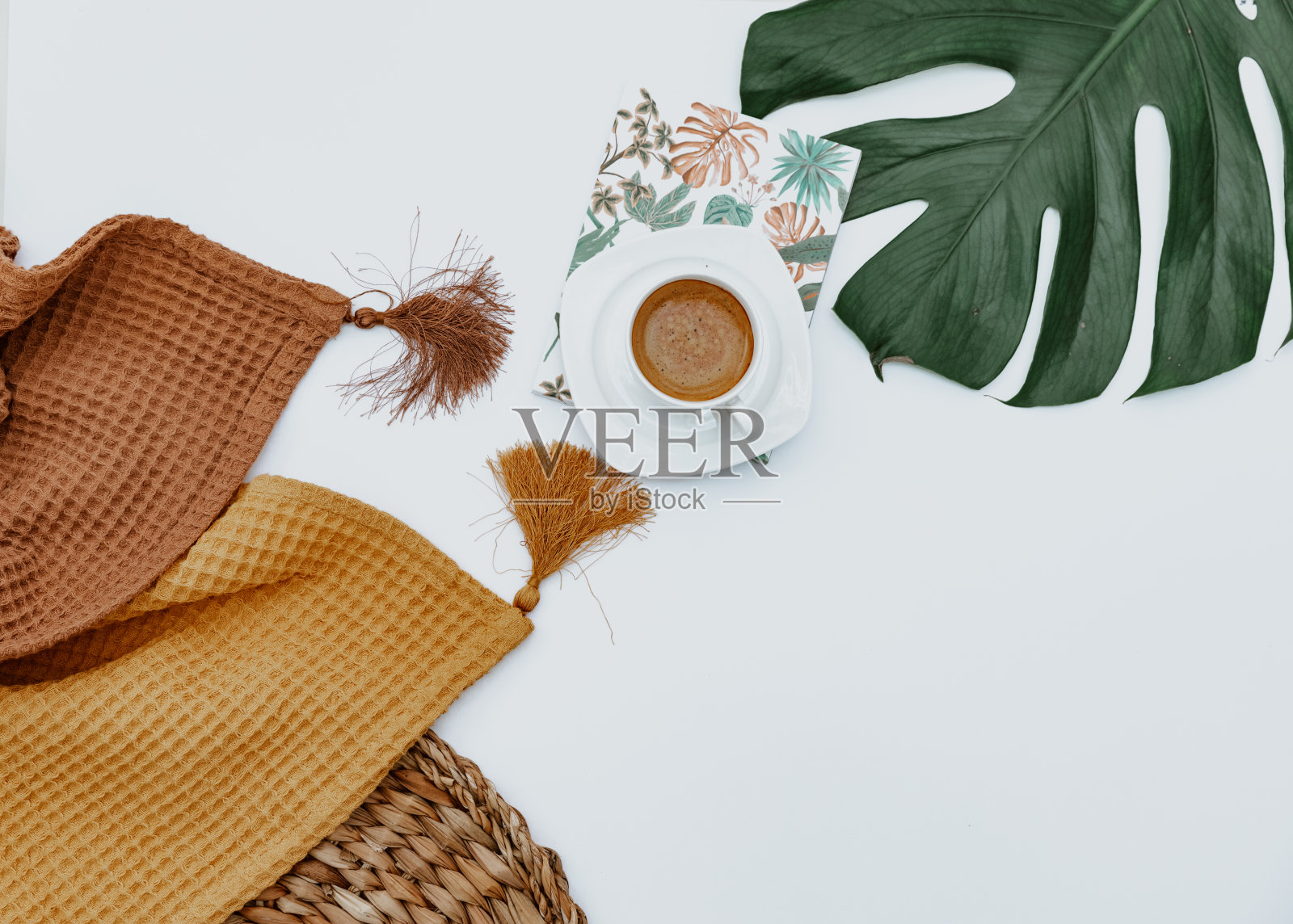 咖啡杯，两条毯子，工艺笔记，白色背景上的怪物叶，最简单的背景。工作区平躺照片摄影图片