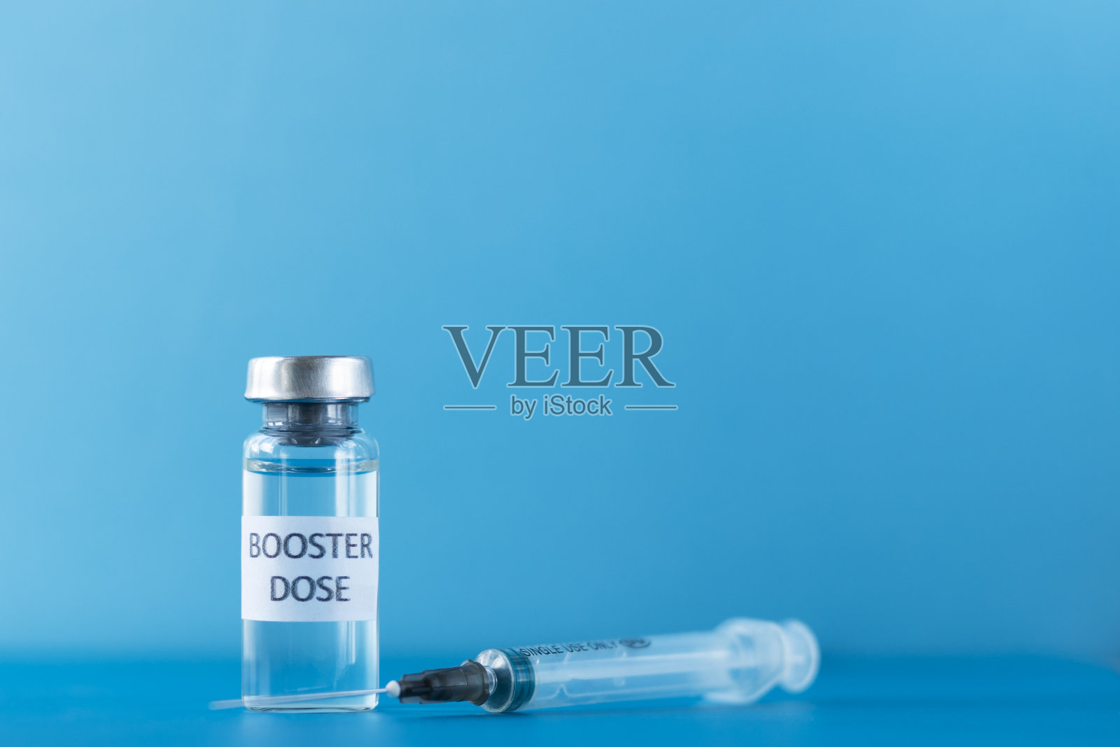 蓝色背景下的小瓶冠状病毒疫苗加强剂照片摄影图片