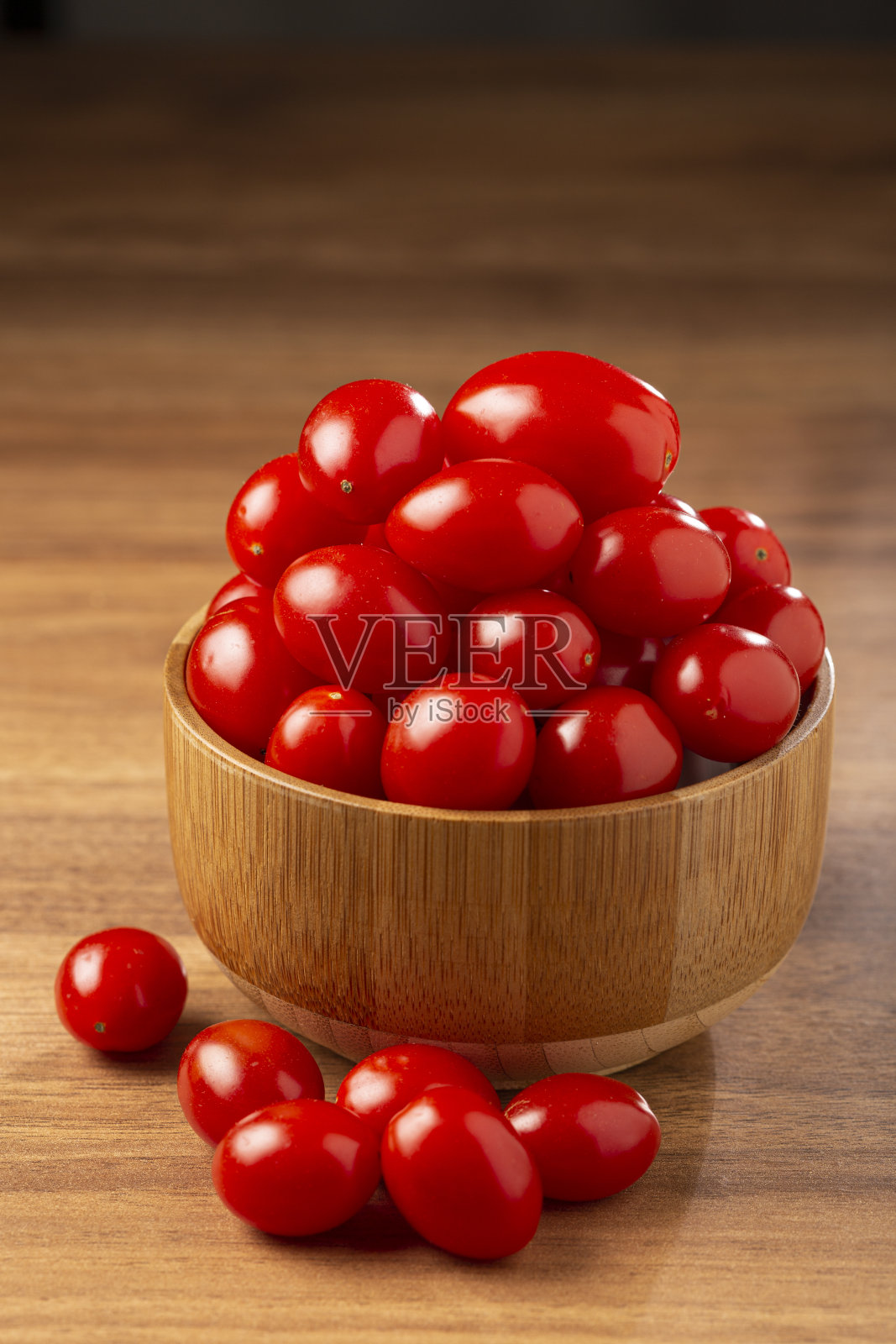 新鲜的葡萄西红柿放在碗里放在桌子上。照片摄影图片