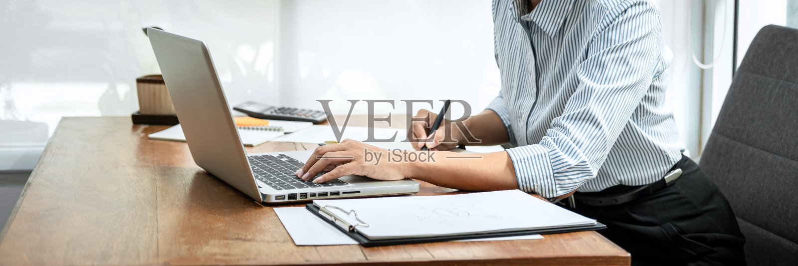 商业女性阅读商业报告，在笔记本电脑上检查财务数据，在文件上写信息照片摄影图片