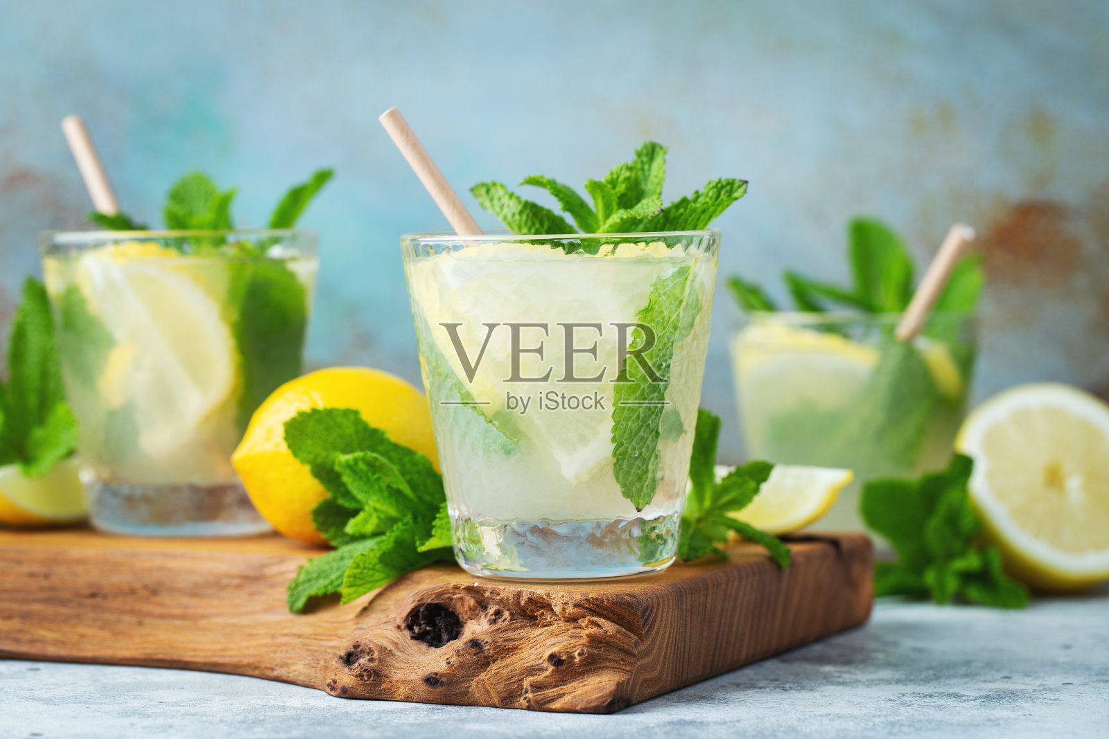 两杯柠檬汁或柠檬和薄荷的莫吉托鸡尾酒，冷饮或冰饮料在乡村蓝色的背景照片摄影图片
