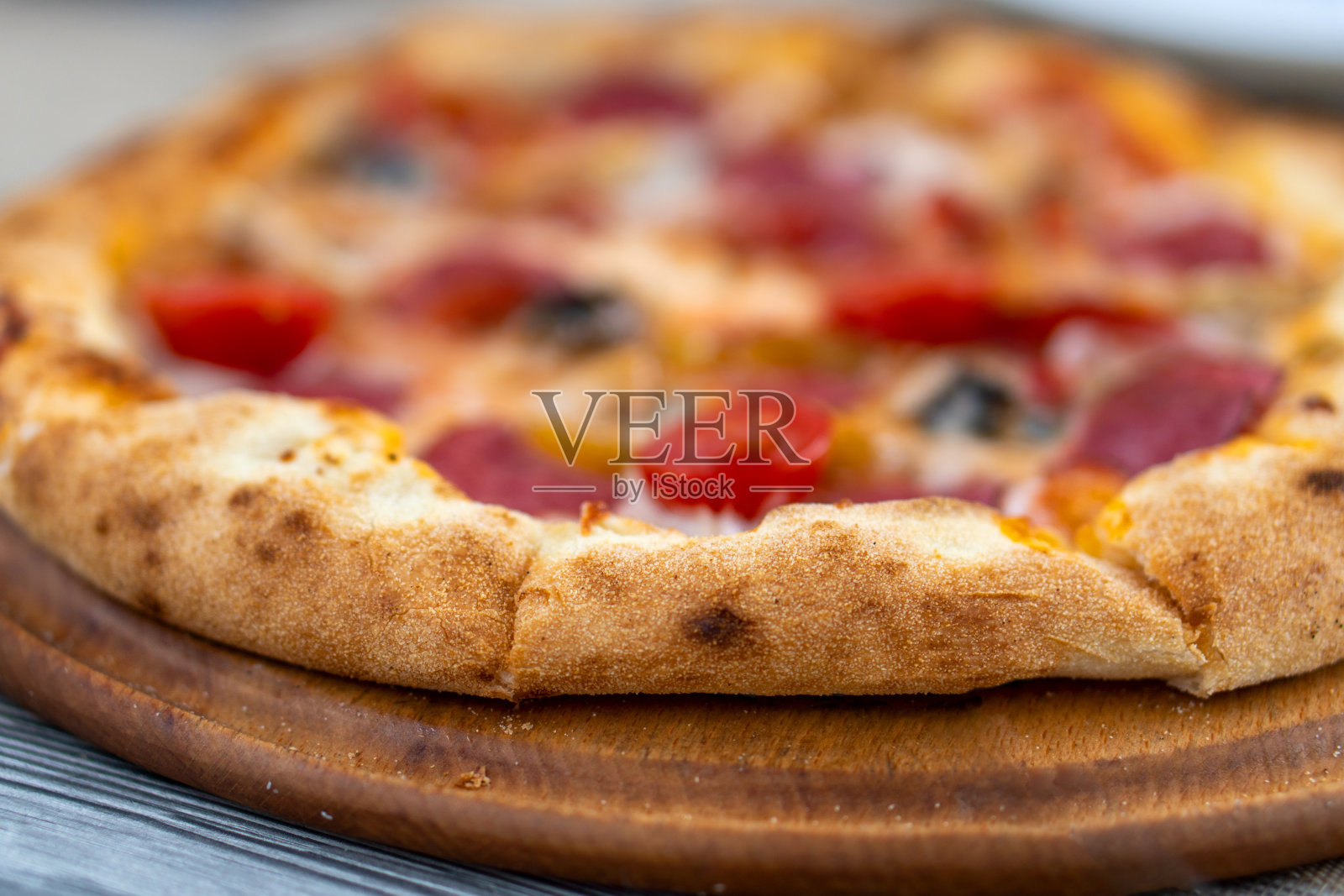 比萨配蕃茄片、意大利卷、芝士和香草，切片。照片摄影图片