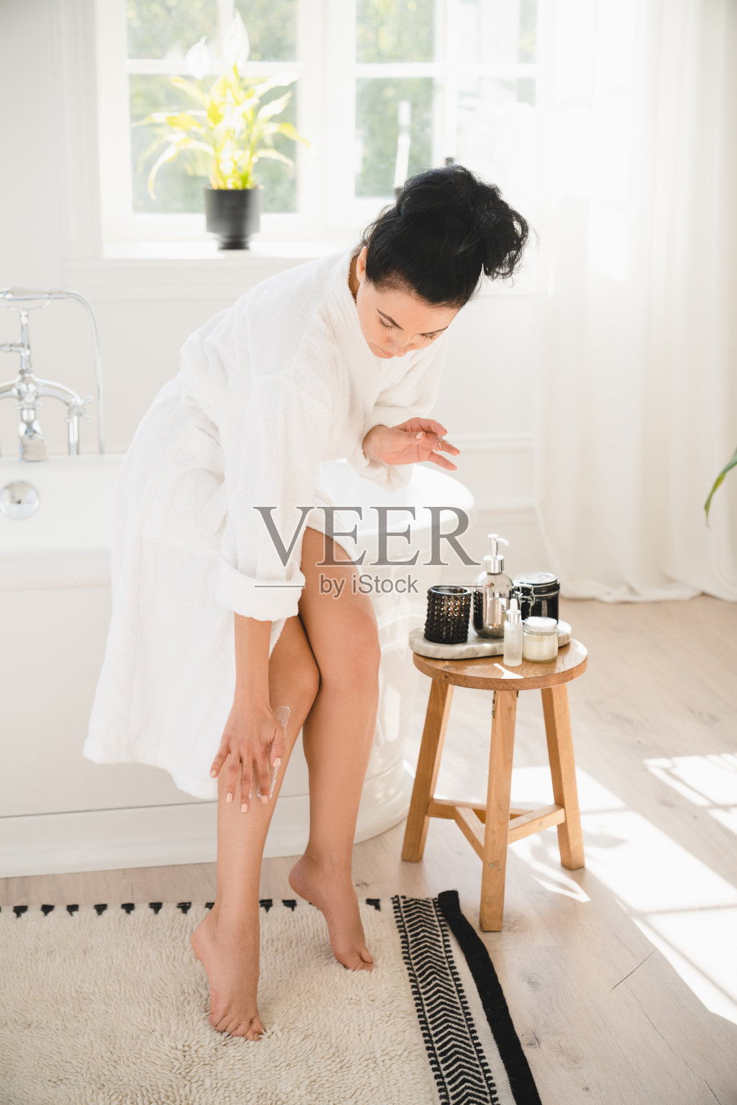 女性剃须后的凝胶霜。白人中年成熟妇女在家中浴室使用剃须膏脱毛脱毛。润肤霜照片摄影图片