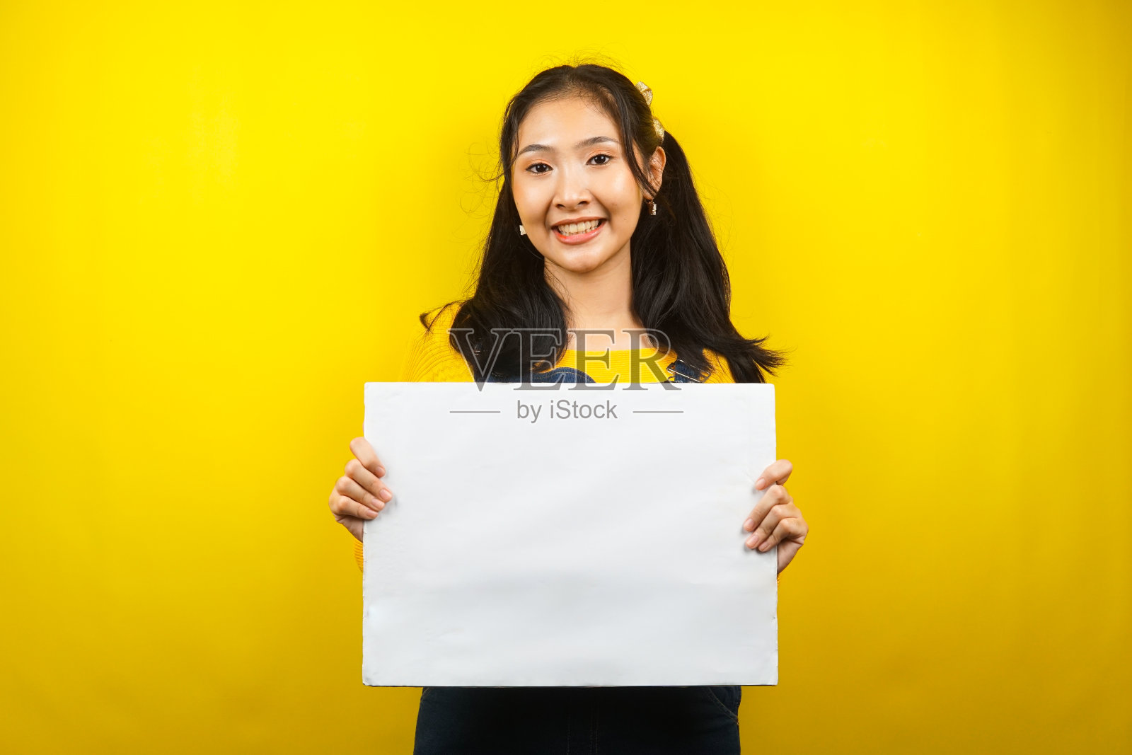 漂亮可爱的年轻女子欢快地拿着空白的空横幅、广告牌、白板、白板招牌、白色广告牌，在文案空间展示东西，促销照片摄影图片