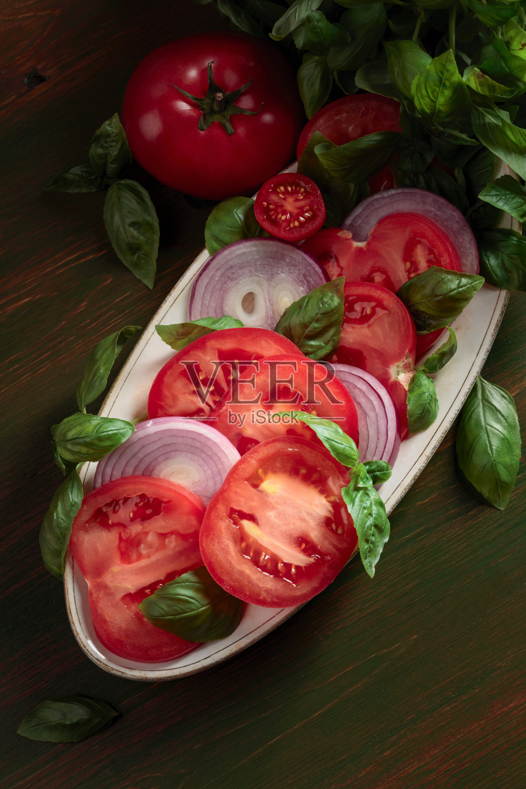 有番茄、罗勒和红洋葱的沙拉。照片摄影图片