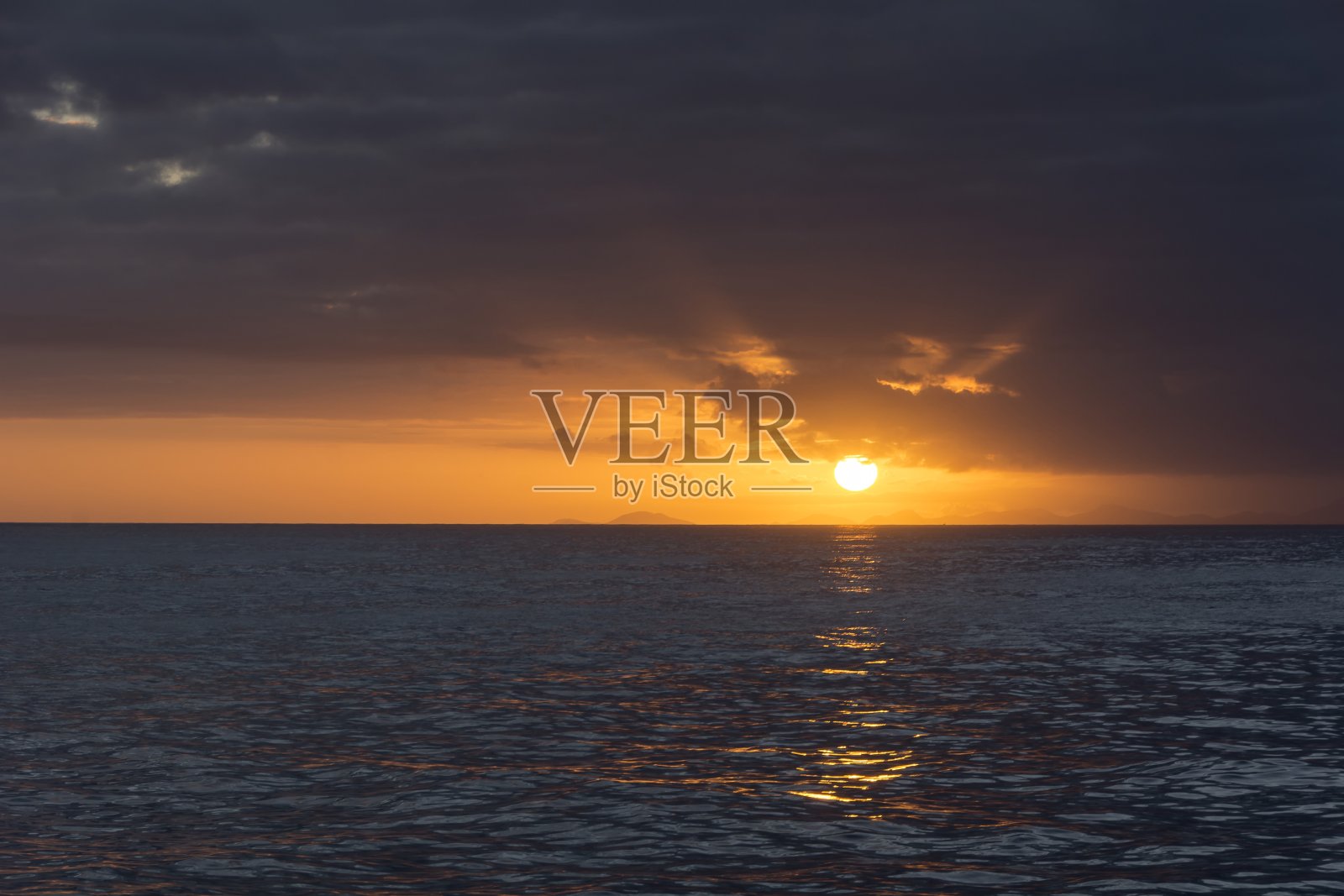 在多云的日子里，大西洋上的日落。照片摄影图片