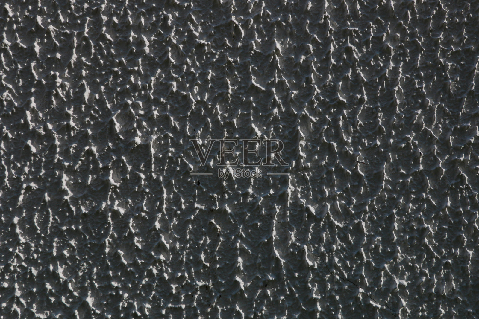 墙壁上的深灰色粗糙浮雕灰泥。照片摄影图片