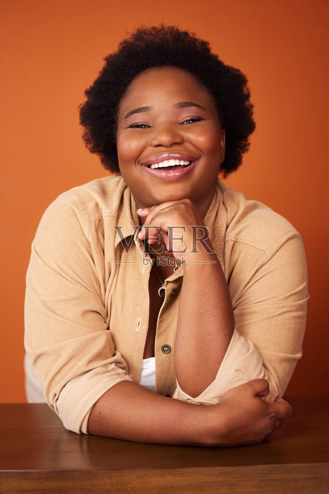 一个年轻女子在橙色背景下摆姿势的照片照片摄影图片