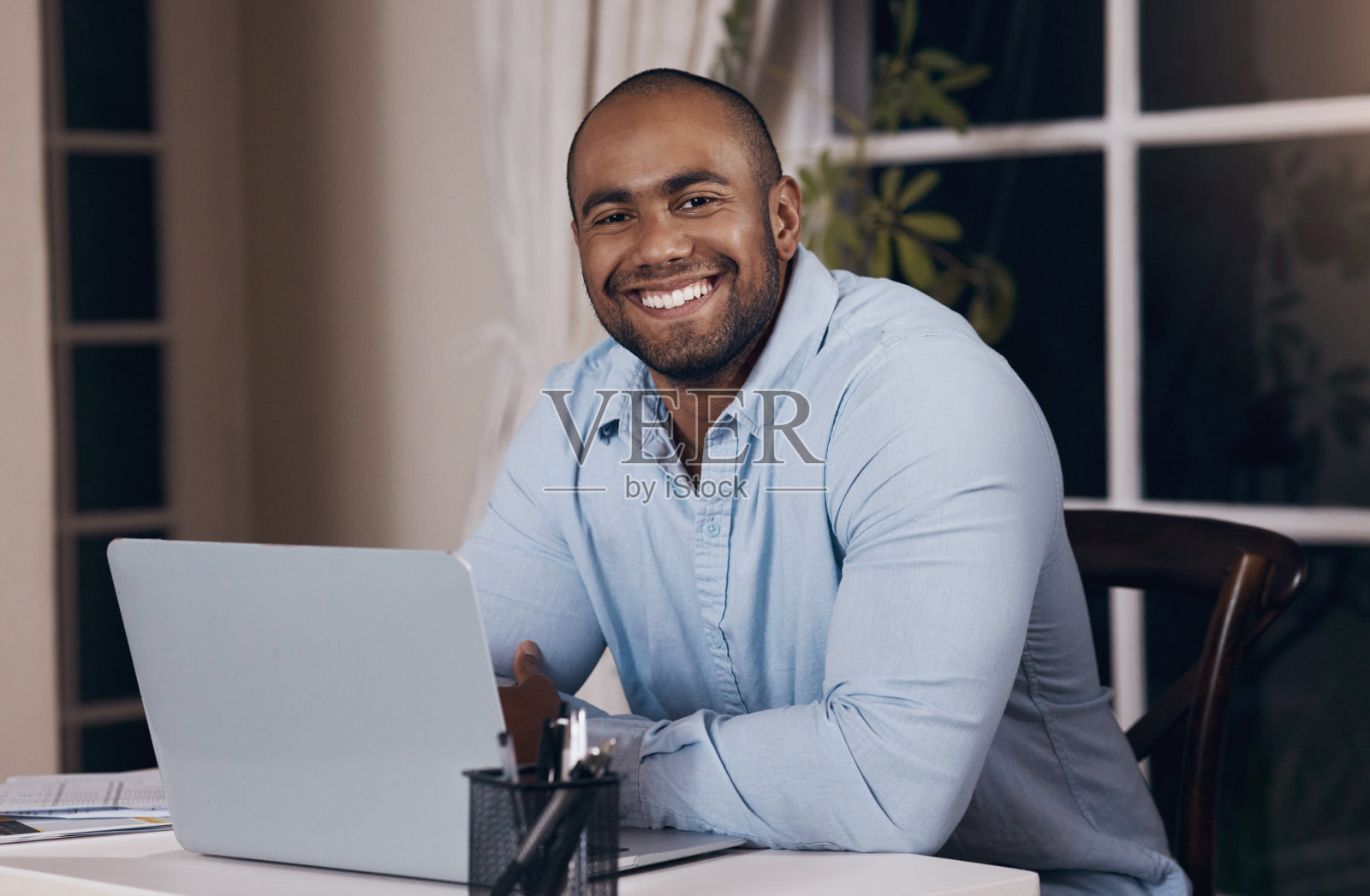 一个年轻的商人在晚上用他的笔记本电脑工作照片摄影图片