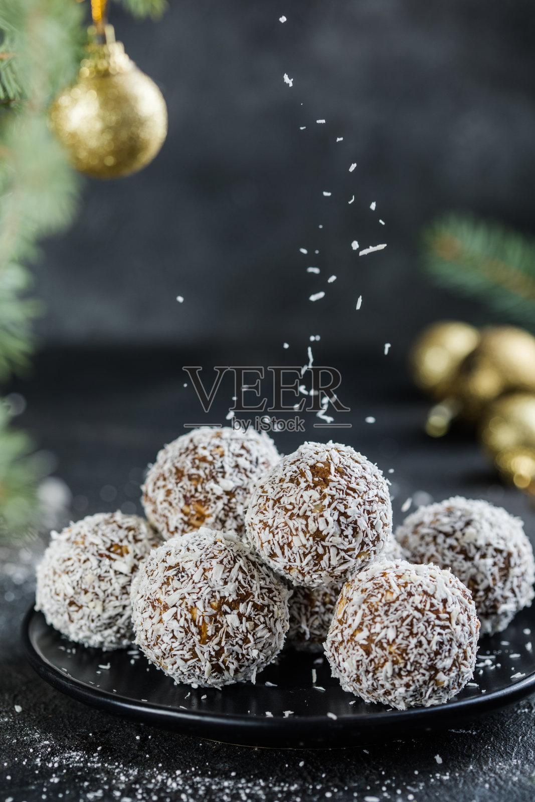 生素食圣诞甜点健康能量球，燕麦片，奇亚籽，椰子片，干果。用冷杉树枝装饰照片摄影图片