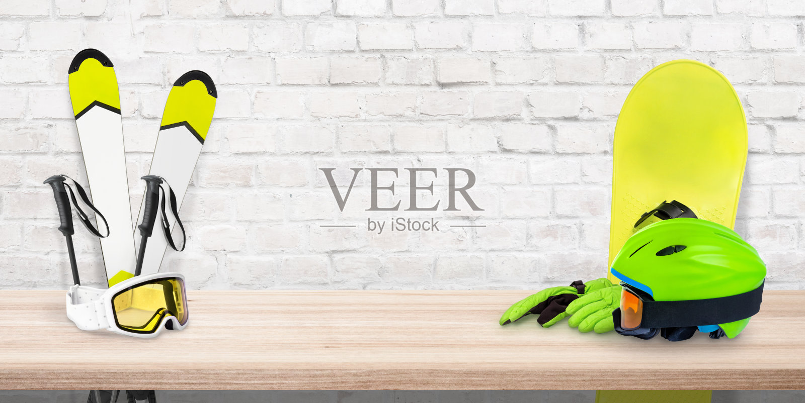 滑雪租赁概念与复制空间在中间的砖墙。滑雪器材放在木制的书桌上照片摄影图片