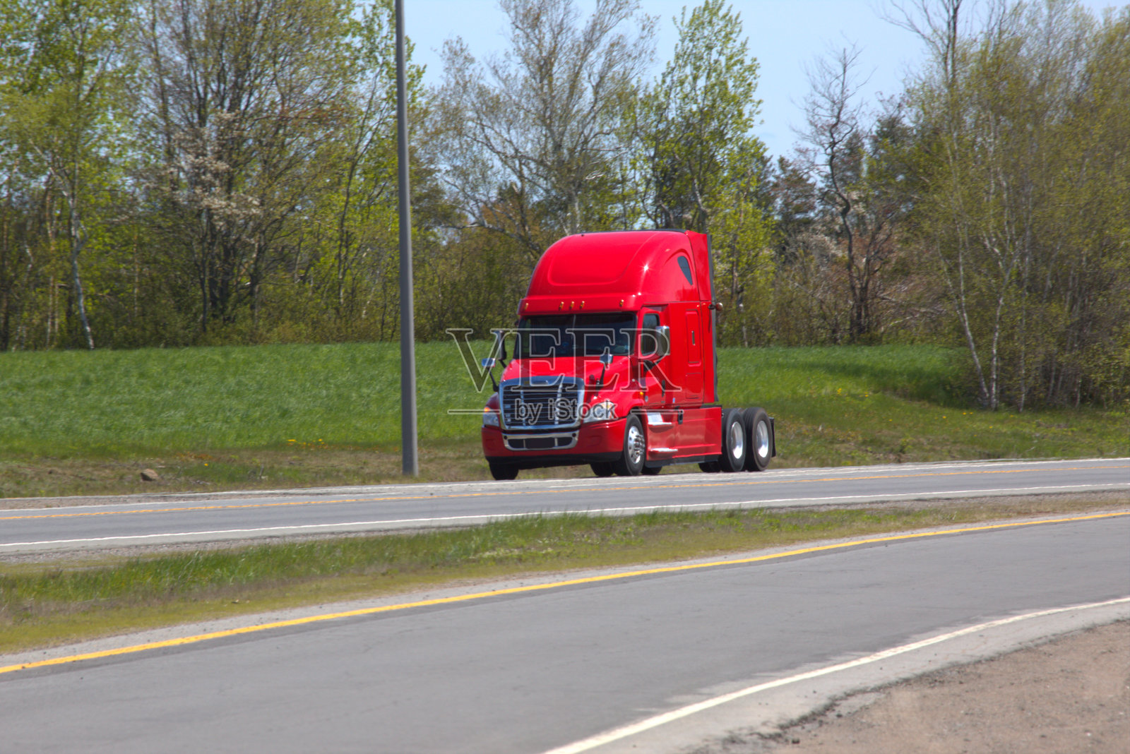 红色半卡车行驶在高速公路上照片摄影图片