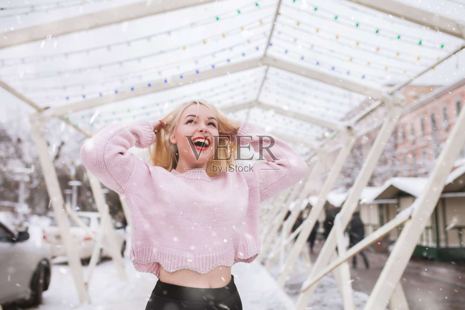 一位积极的女士在大雪中漫步在节日集市上照片摄影图片