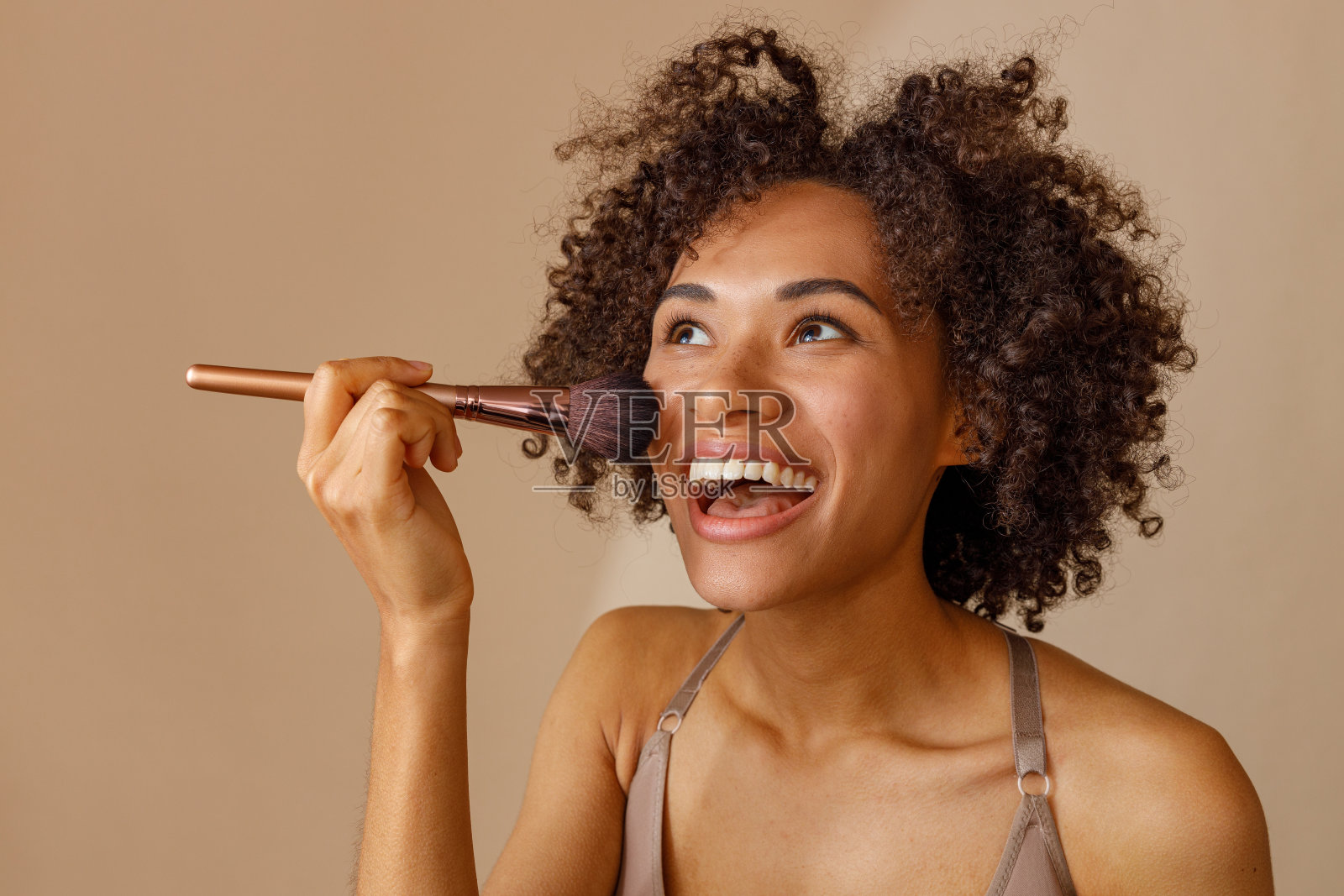 迷人的多种族妇女摆对米色墙照片摄影图片