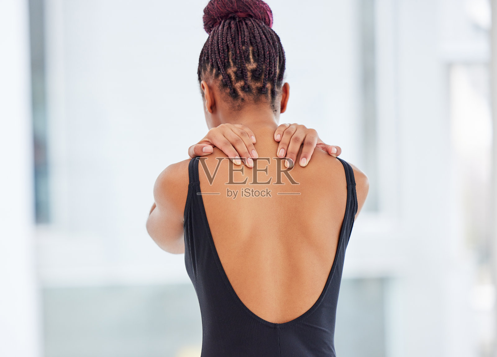 一个年轻的芭蕾舞女演员的肩膀疼痛照片摄影图片