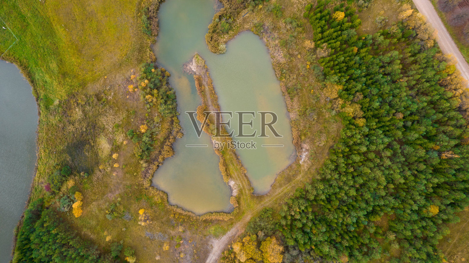 小湖或池塘的不同寻常的形状与美丽的秋天自然照片从上面用无人机。照片摄影图片
