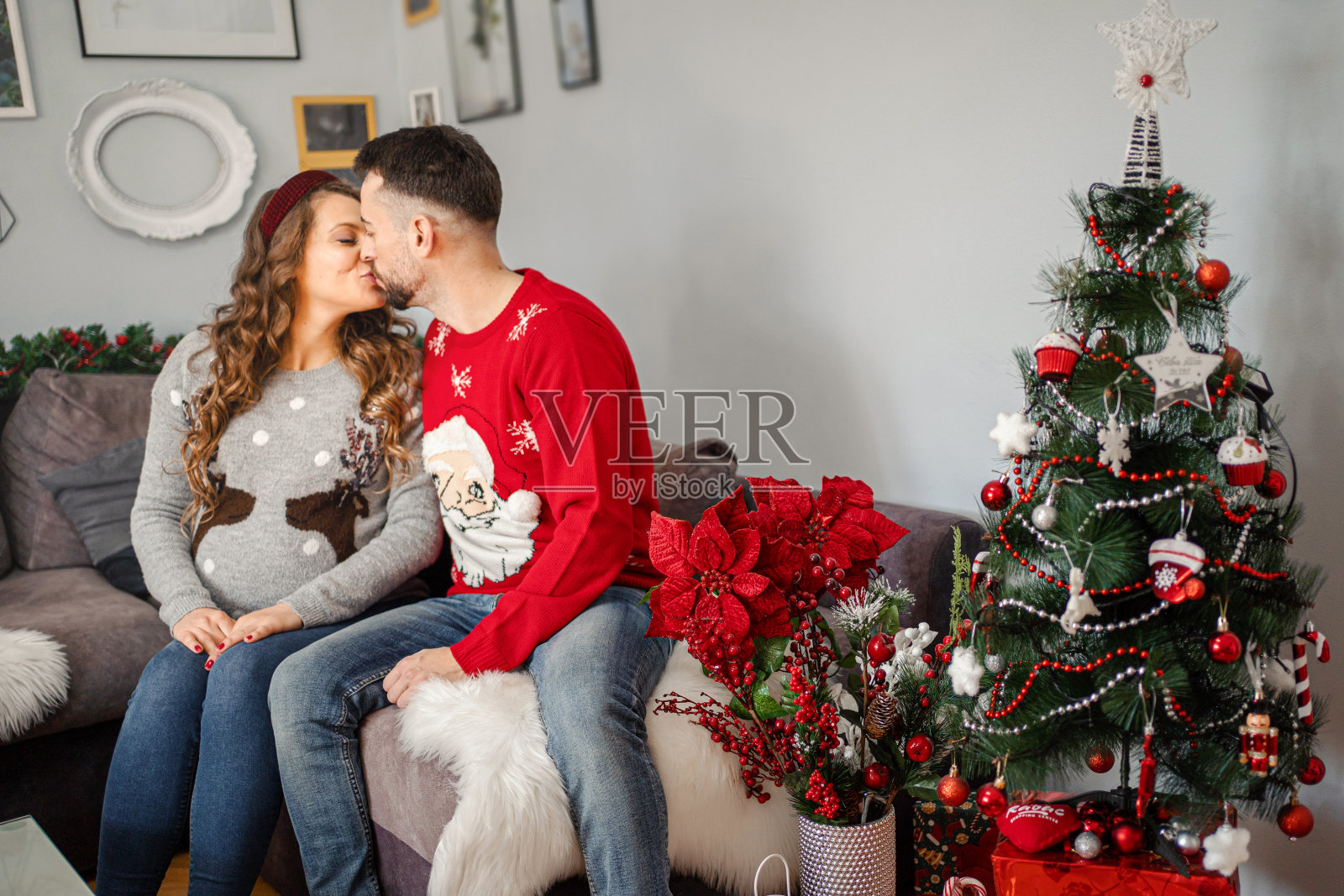 一对年轻夫妇坐在客厅的沙发上接吻照片摄影图片