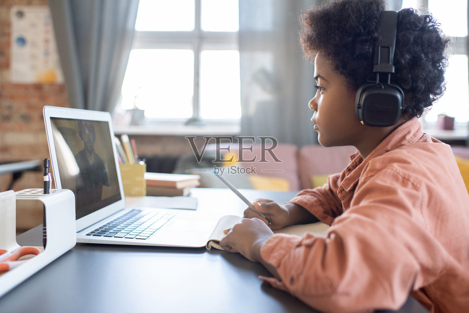 可爱严肃的小男生戴着耳机听老师讲解照片摄影图片