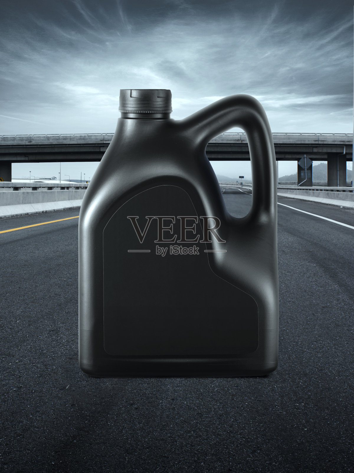 黑色塑料机油罐。在公路上照片摄影图片