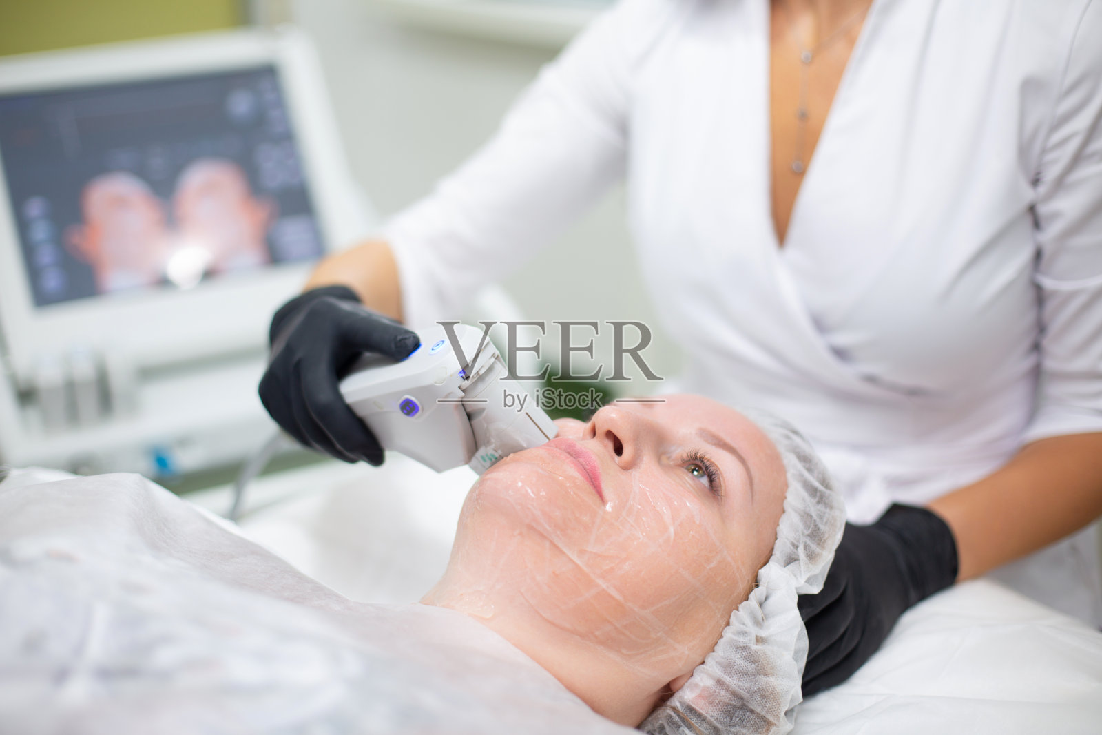 一位妇女在美容办公室接受SMAS提升程序。非手术超声波面部拉皮，嫩肤，保湿，消除皱纹，肤色和弹性照片摄影图片