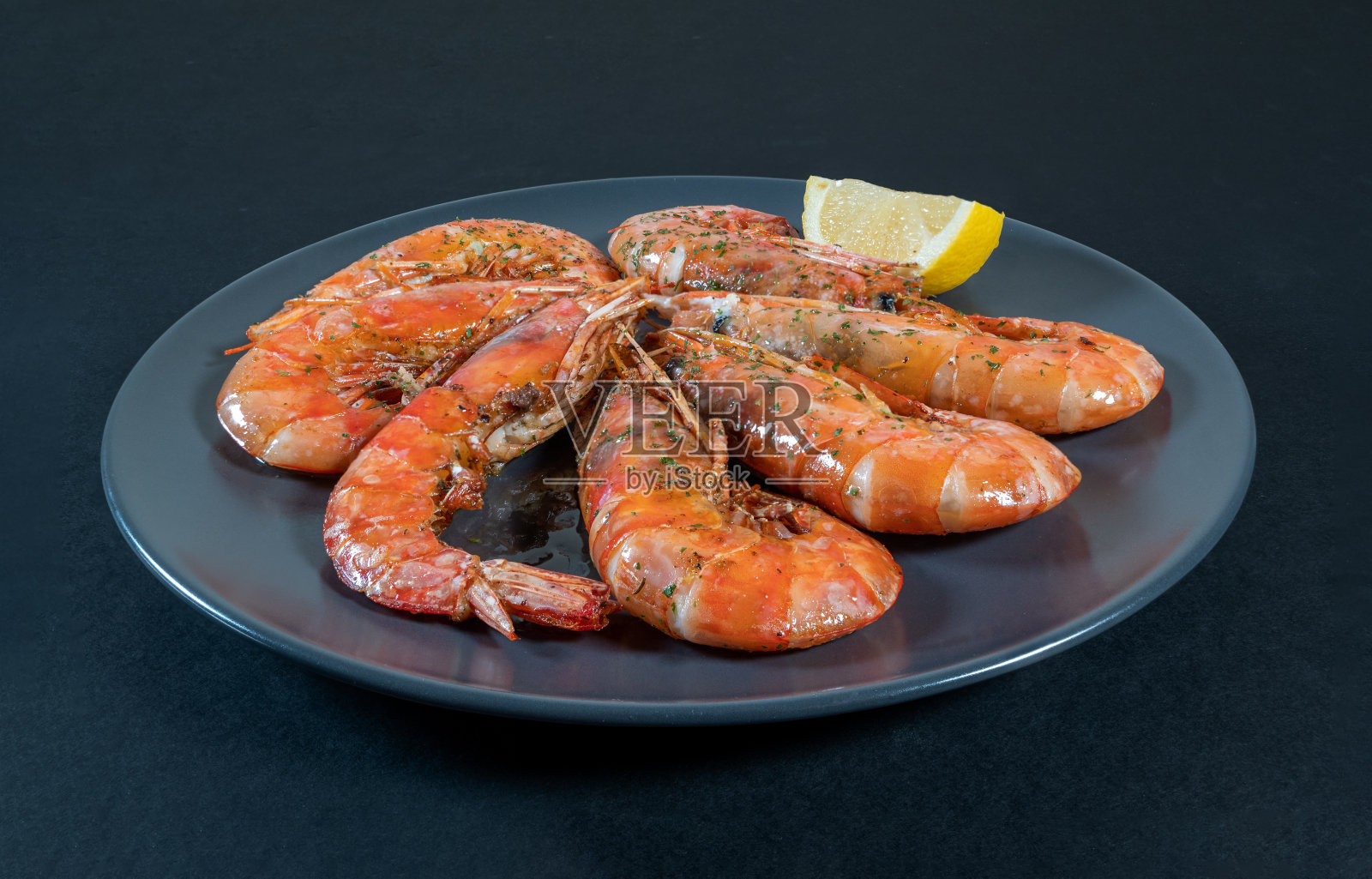 一盘黑底烤虾照片摄影图片