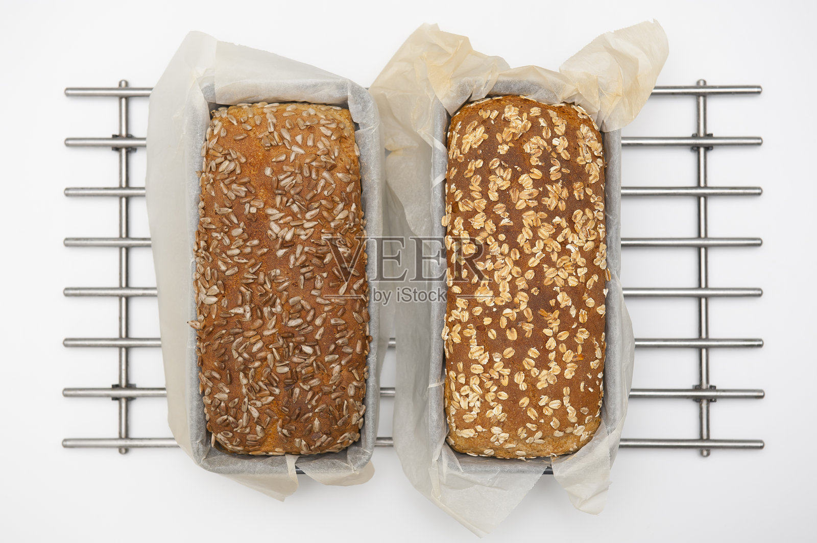 两个新鲜的面包放在钢制三脚架上照片摄影图片