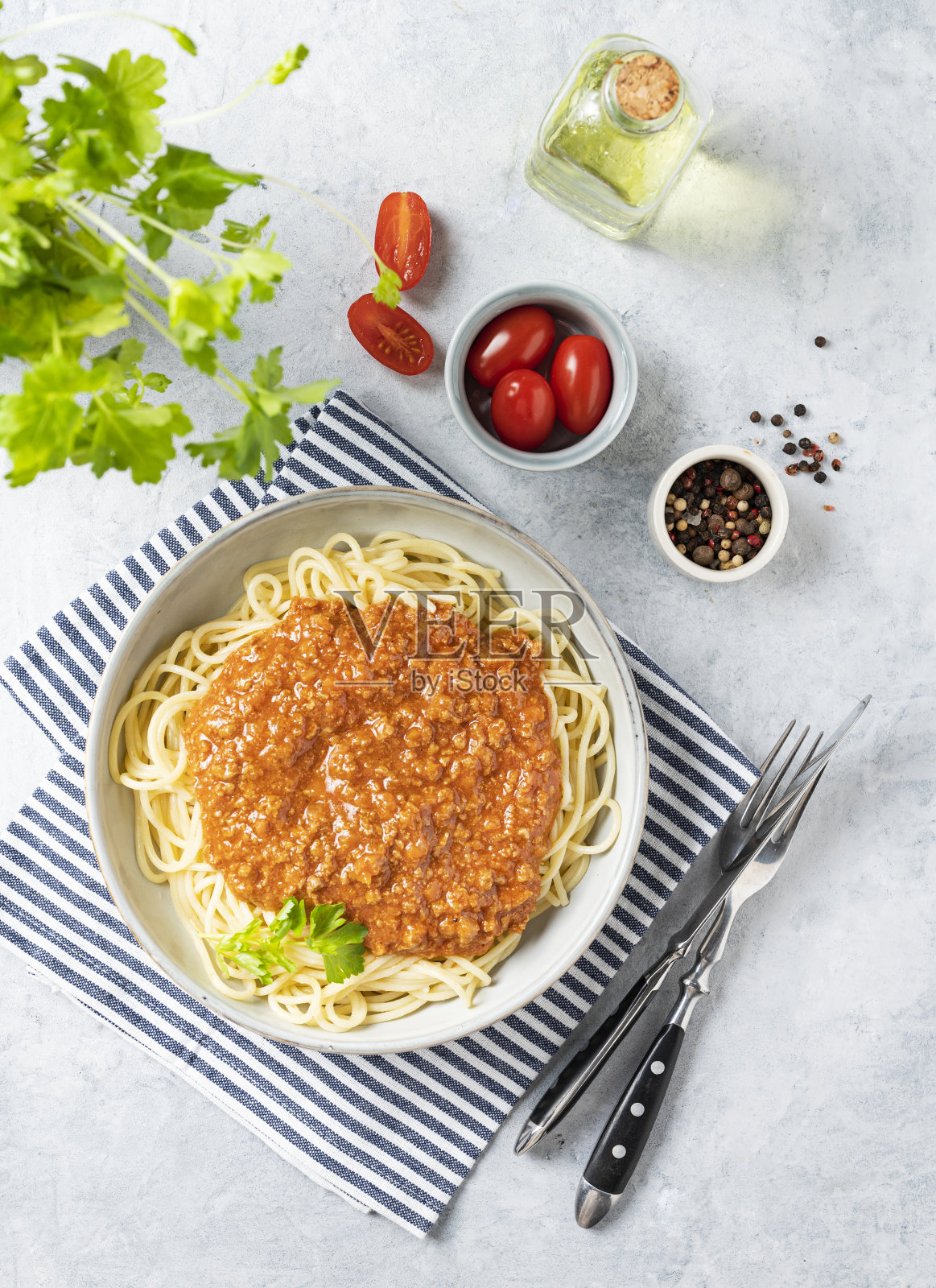 美味的意大利肉酱面配以番茄酱、帕玛森芝士和新鲜香草，配以番茄和橄榄油。意大利料理的概念。俯视图照片摄影图片