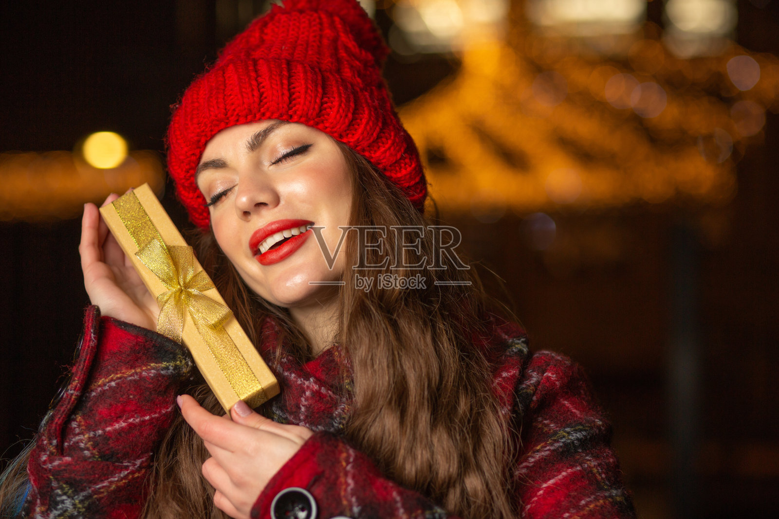 可爱的女士戴着红帽拿着礼盒照片摄影图片