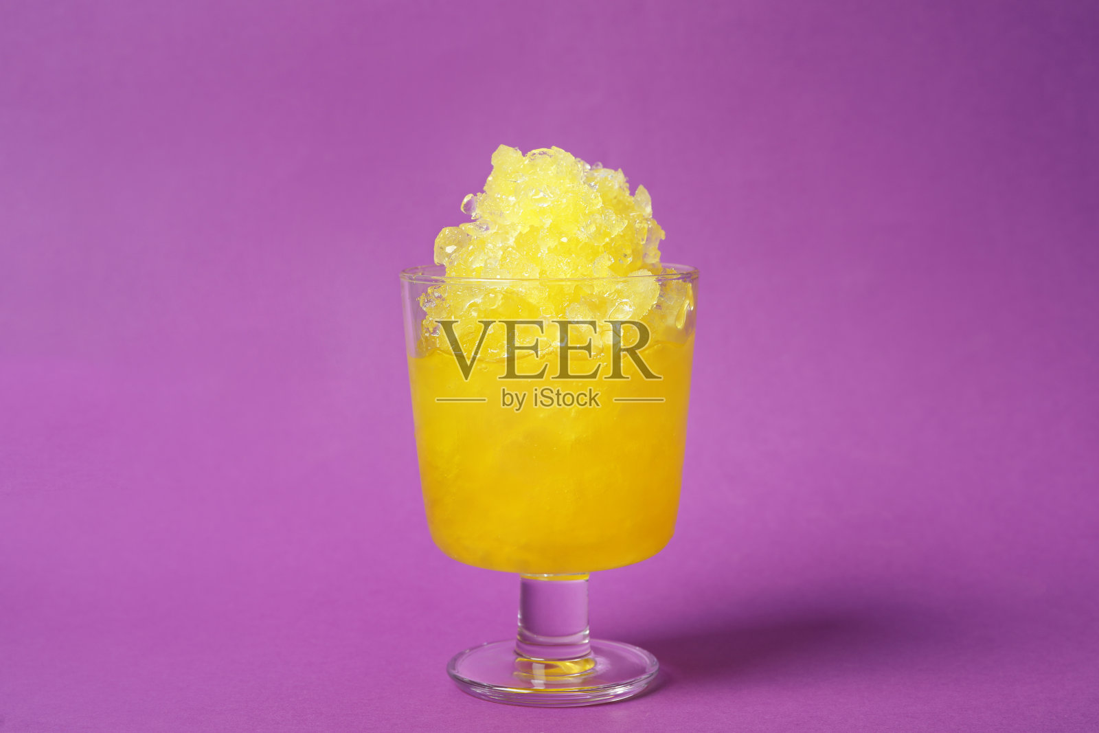 在紫色背景的玻璃甜品碗里剃冰照片摄影图片