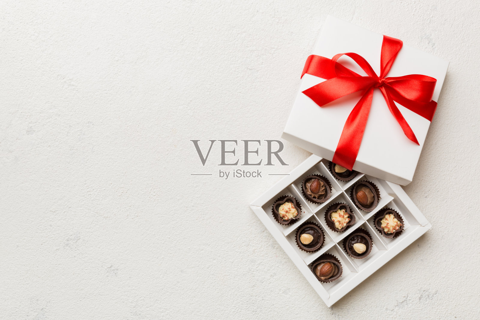 情人节的美味巧克力果仁糖红盒。心形巧克力盒顶视图与复制空间照片摄影图片