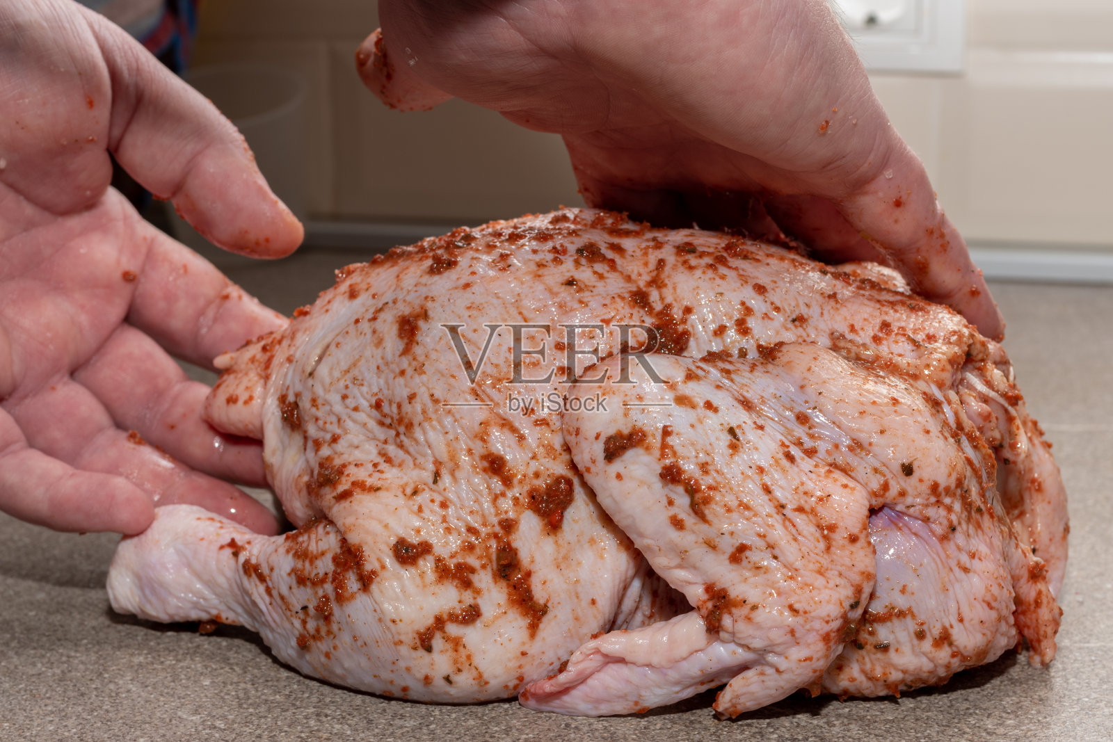 特写，男性的手盖满了酱汁的生鸡肉。为晚餐和午餐烹制肉类菜肴。照片摄影图片