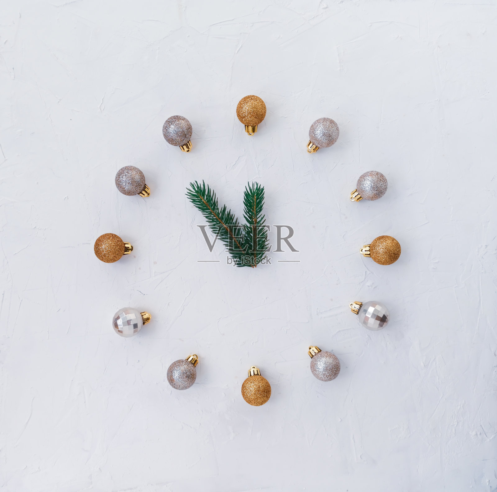 带着蓝色球的蕨枝代替了圣诞节庆祝新年的音乐会。用圣诞树玩具，闪亮的球做的钟。时钟的指针是用绿色云杉树枝做成的。照片摄影图片