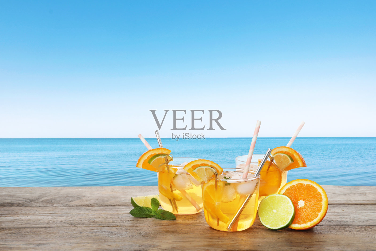 背对大海的木桌上，可口的清凉饮料照片摄影图片