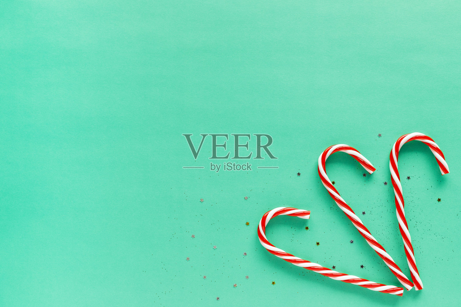 圣诞白色蚂蚁红色节日糖果手杖在绿色的背景与复制空间照片摄影图片