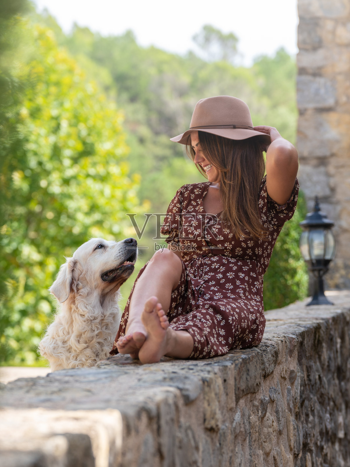 一个年轻女人和她的白狗。他们互相看着对方照片摄影图片