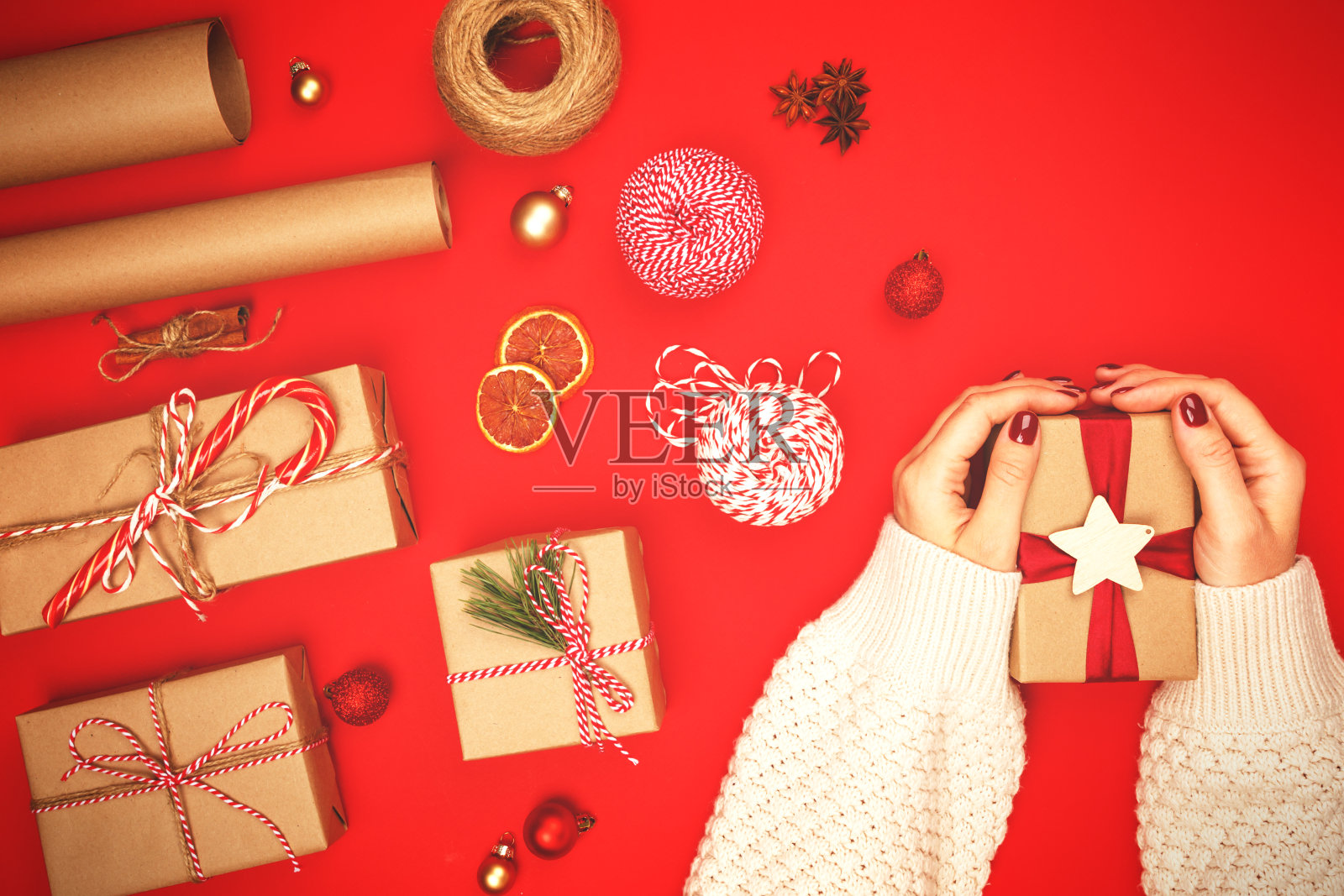 女性手中的圣诞礼物以红色为背景照片摄影图片