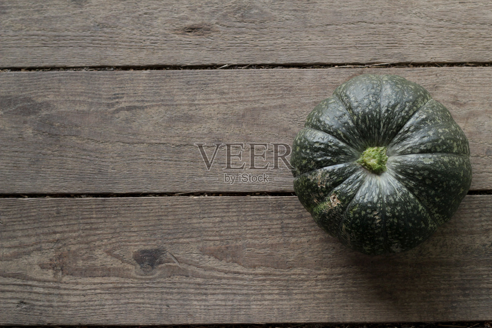 木质背景上有绿色果皮的成熟南瓜。木板。平铺，俯视图。文本空间，复制空间。南瓜品种。照片摄影图片
