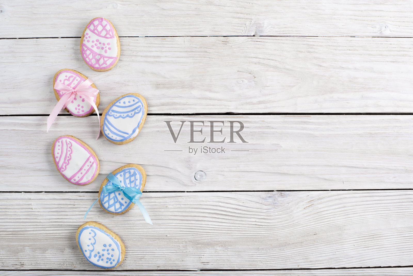 自制复活节饼干形状的鸡蛋在白色木制厨房桌子上平放的观点。空间的文本照片摄影图片