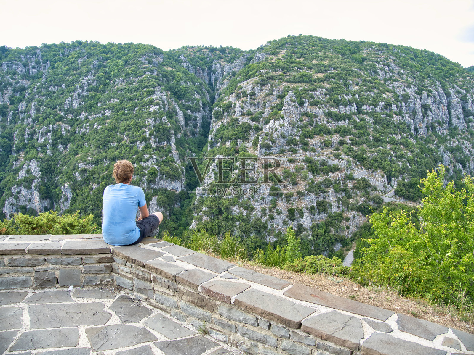 在维克斯峡谷地区的Zagori村，一名年轻人在弗拉德托台阶上欣赏风景照片摄影图片